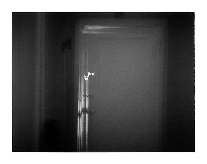 photograph of a door at the end of a dark hallway by Alan Ostreicher