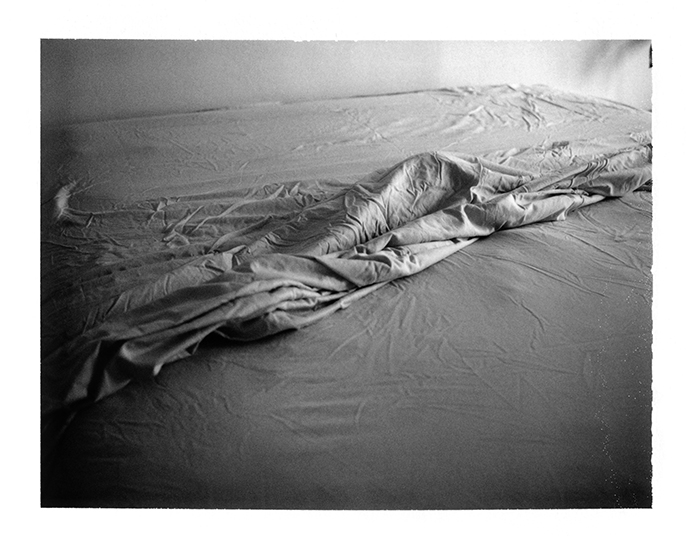 photograph of an unmade bed by Alan Ostreicher