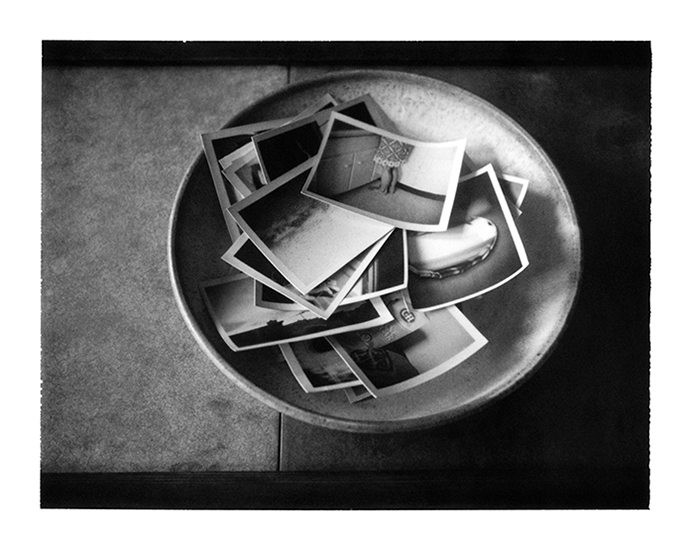 photograph of a pile of small photographs in a bowl by Alan Ostreicher